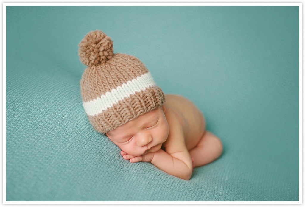 newborn boy with brown pouf hat