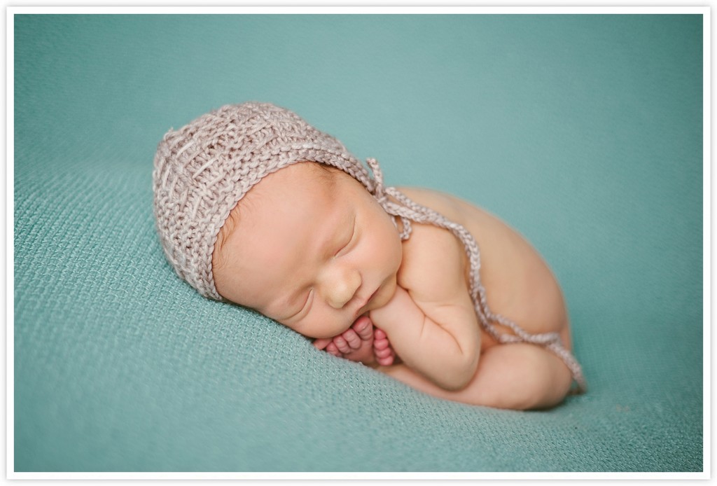 Newborn boy with brown tied knit hat