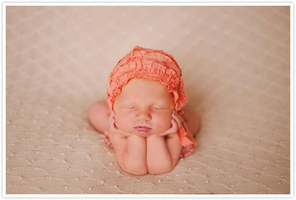 newborn baby in bonnet and froggy pose