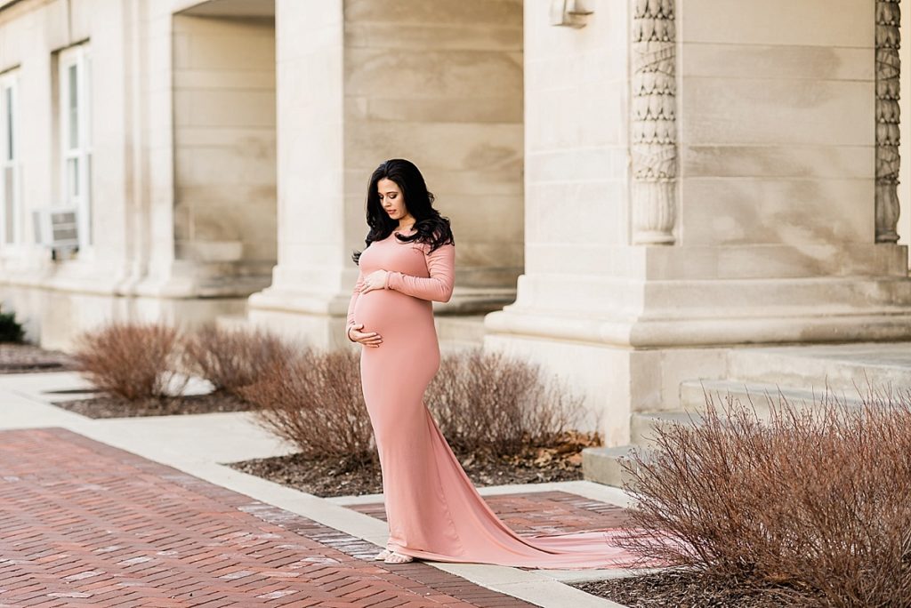 Long dress winter maternity photos with classic architecture in East Lansing, Michigan