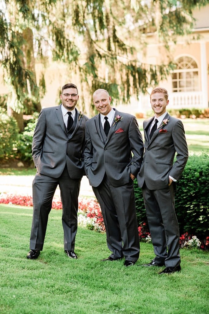 Groomsmen photos in the gardens of The English Inn, a Lansing wedding venue, by Allie & Co. Lansing wedding photographers