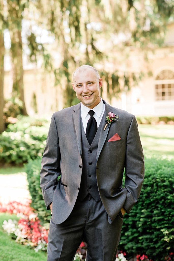 Groom photos in the gardens of The English Inn, a Lansing wedding venue, by Allie & Co. Lansing wedding photographers