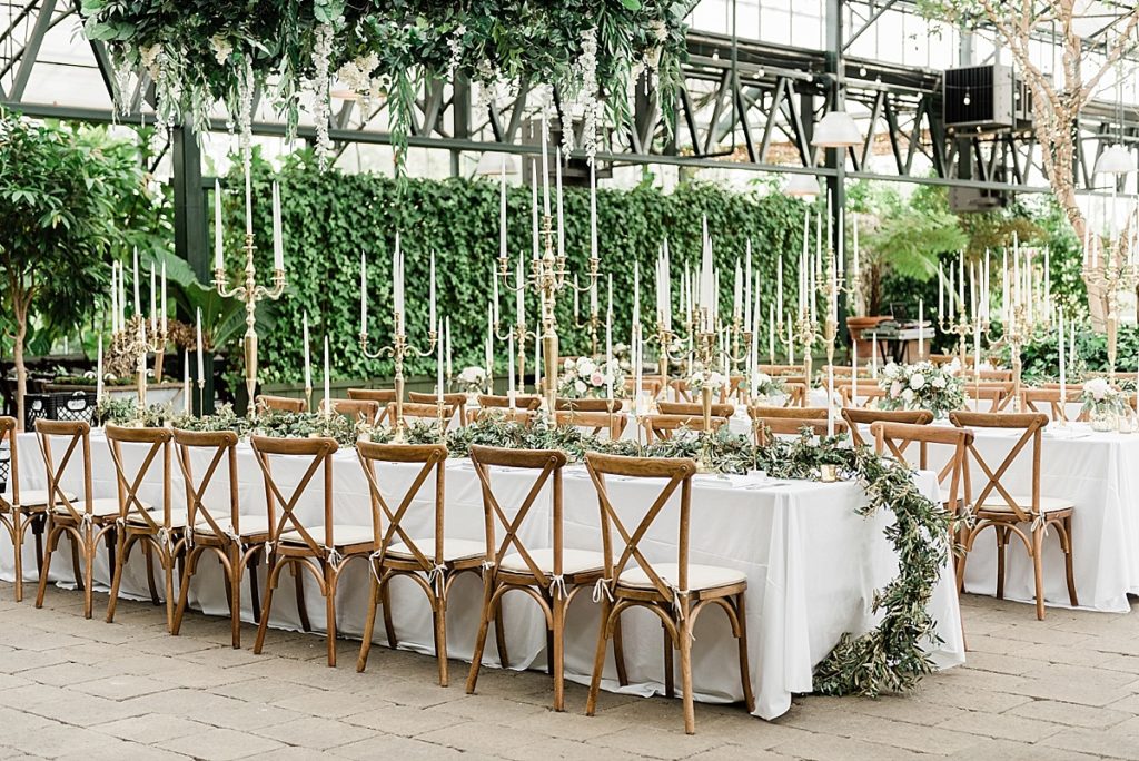 reception design, flowers, garland, long candles, long tables, wooden chairs; Planterra Conservatory, Wedding Photos in West Bloomfield, Michigan, by Allie & Co. wedding photographers