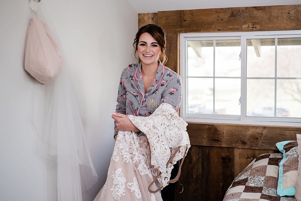 a photo of the bride getting ready in the bedroom of the Stone House Farm house