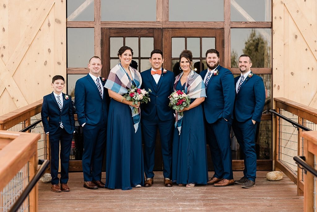 Wedding party photo in front of the barn doors at the Stone House Farm wedding venue