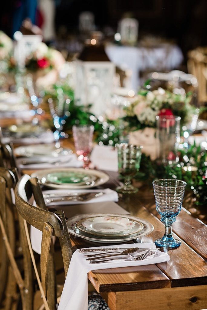 photos of the wedding reception room, including vintage china place settings on a wooden table at Stone House Farm, a Michigan barn wedding venue, by Allie & Co. Photography, Michigan wedding photographers