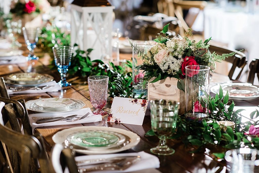 photos of the wedding reception room, including vintage china place settings on a wooden table at Stone House Farm, a Michigan barn wedding venue, by Allie & Co. Photography, Michigan wedding photographers