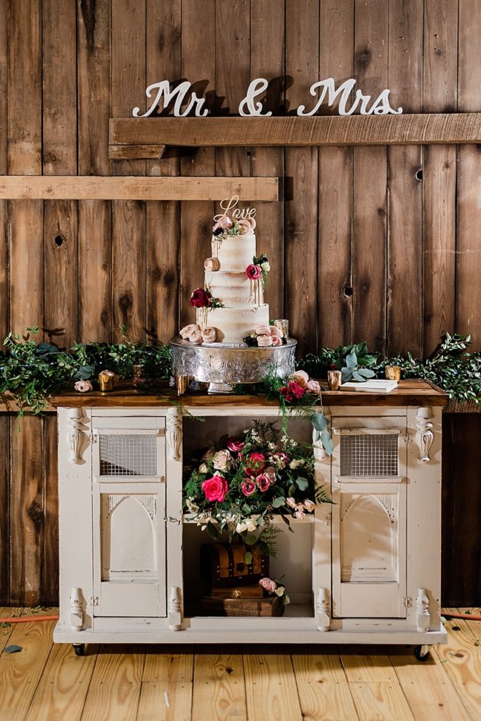 wedding cake display on a wooden table at Stone House Farm, a Michigan barn wedding venue, by Allie & Co. Photography, Michigan wedding photographers