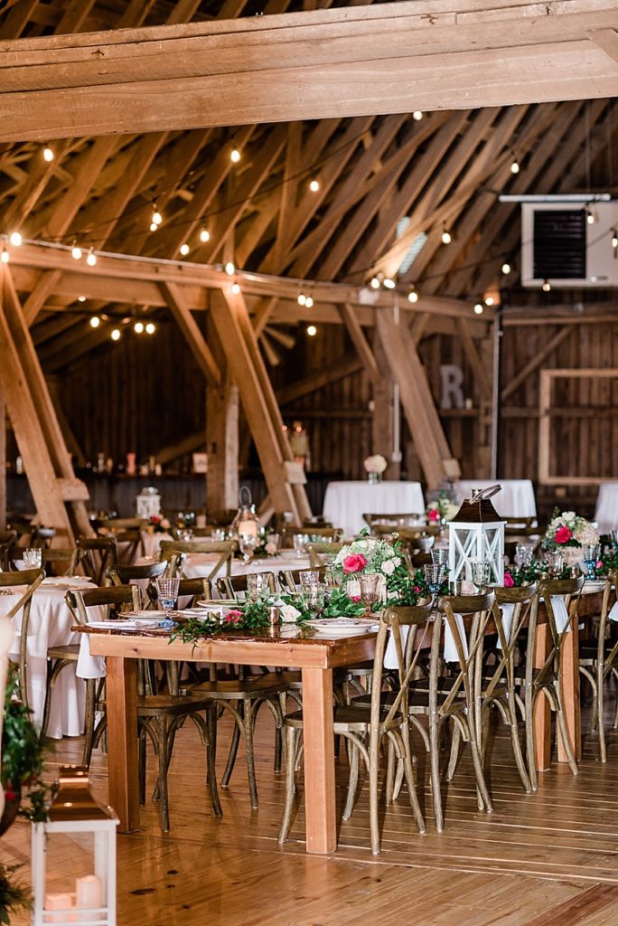 photos of the wedding reception room, including the wedding party table with vintage china place settings on a wooden table at Stone House Farm, a Michigan barn wedding venue, by Allie & Co. Photography, Michigan wedding photographers