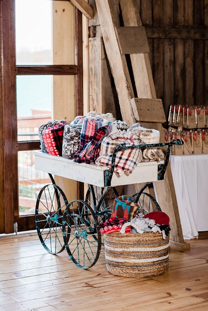 A basket of blankets for an outdoor late fall wedding at Stone House Farm, a Michigan barn wedding venue, by Allie & Co. Photography, Michigan wedding photographers