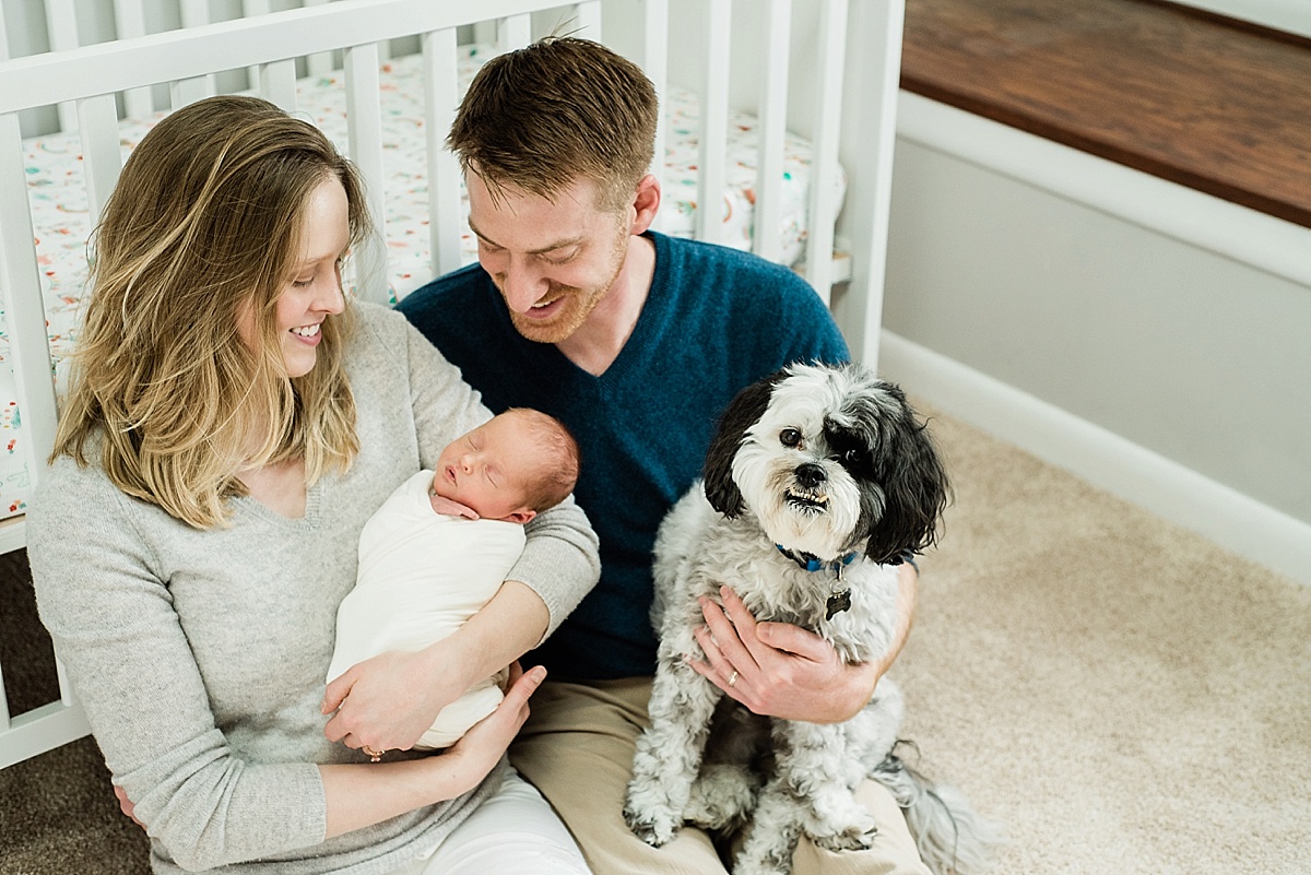 Lifestyle newborn photography at home with a crib in the background in Lansing, Michigan