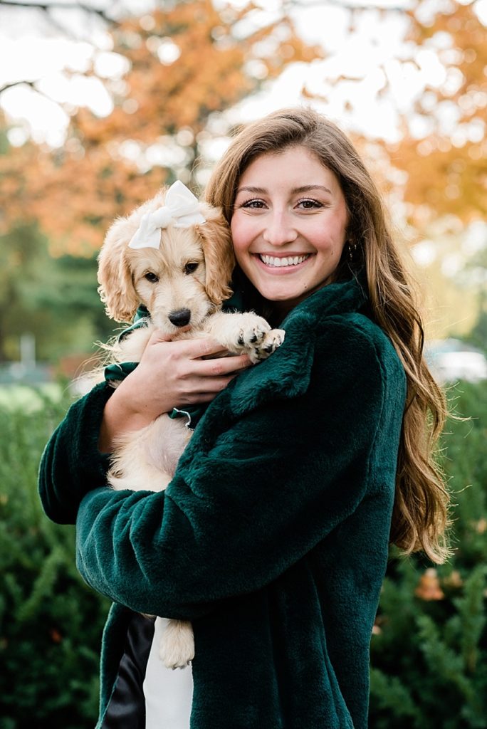 Ideas and locations for a Michigan State University fall senior photo session on north campus by Allie Siarto Photography, East Lansing Photographers. A photo showing a senior holding her puppy with fall colors.