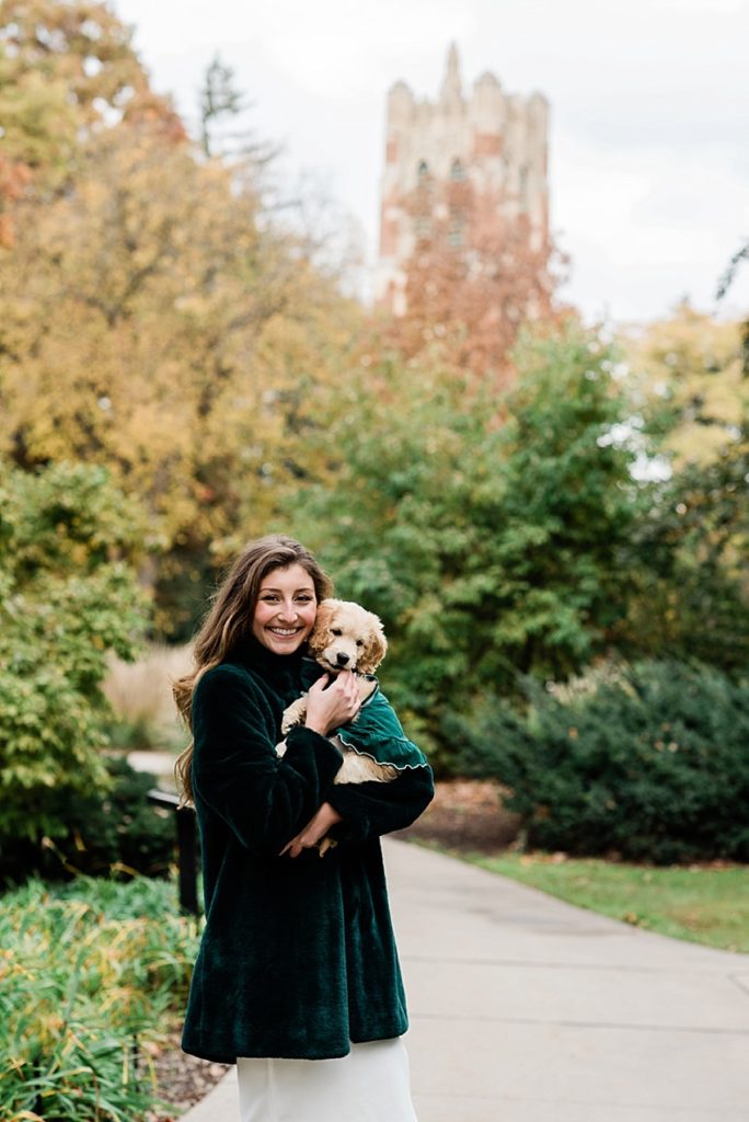 Ideas and locations for a Michigan State University fall senior photo session on north campus by Allie Siarto Photography, East Lansing Photographers. A photo of an MSU senior holding her puppy with Beaumont Tower in the background.