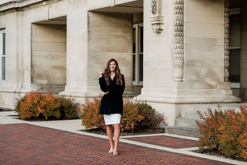 Ideas and locations for a Michigan State University fall senior photo session on north campus by Allie Siarto Photography, East Lansing Photographers. A photo of an MSU senior standing in front of the classic architecture of MSU's campus.