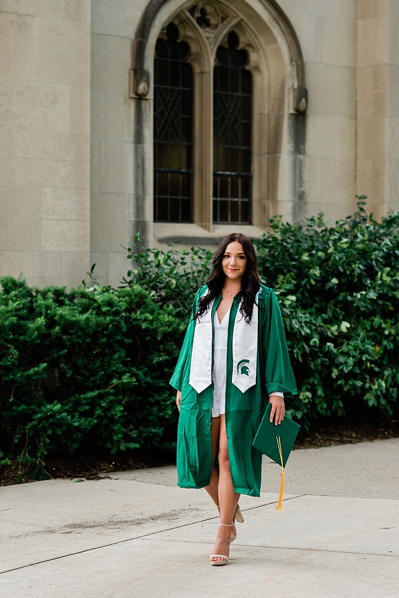 Michigan State Senior Pictures with a girl in a white dress and cap and gown on MSU's campus by Beaumont Tower, by Allie Siarto & Co. Photography, MSU graduation photographers