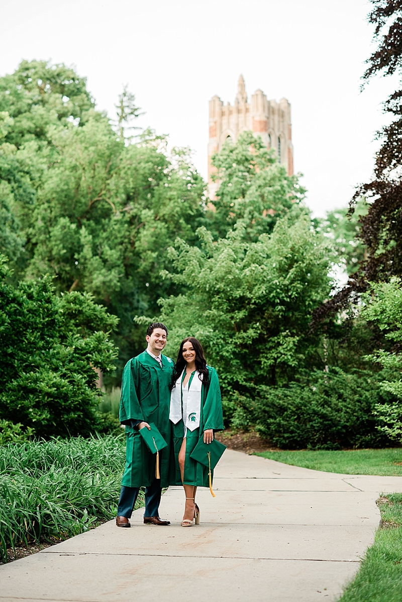 Michigan State Senior Pictures with a couple in cap and gown on MSU's campus with Beaumont Tower in the background, by Allie Siarto & Co. Photography, MSU graduation photographers