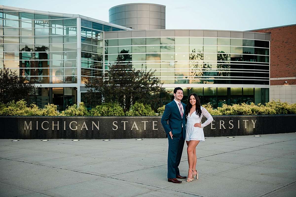 Michigan State Senior Pictures with a couple in a suit and white dress on MSU's campus in front of the Clara Bell Smith Center, by Allie Siarto & Co. Photography, MSU graduation photographers