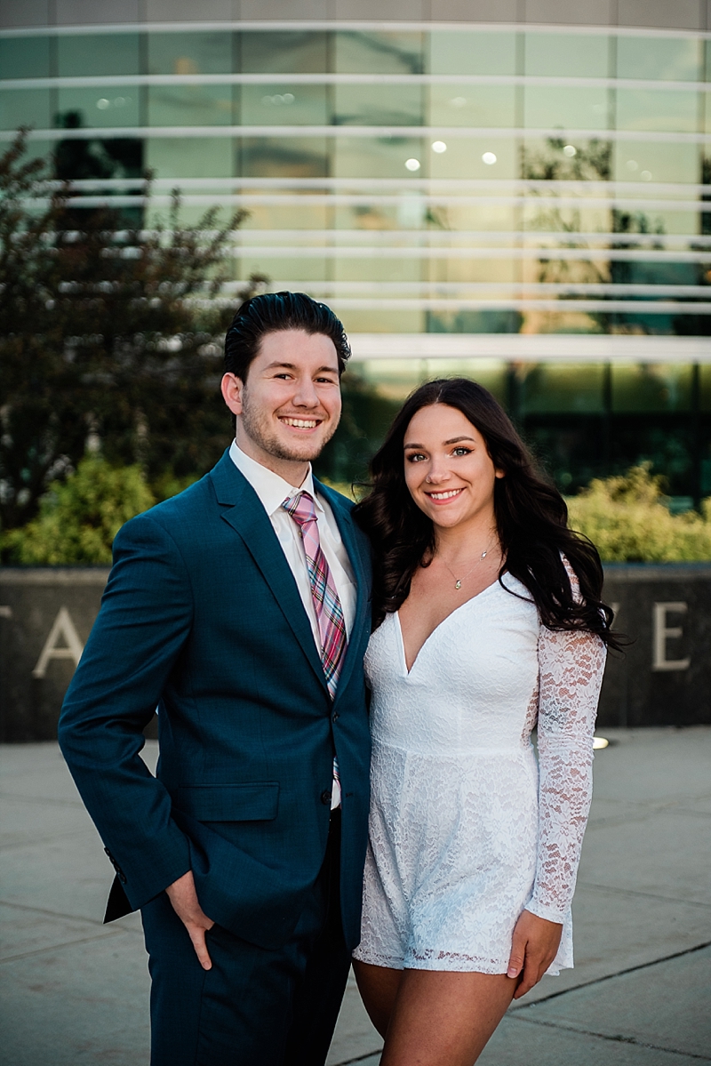 Michigan State Senior Pictures with a couple in a suit and white dress on MSU's campus in front of the Clara Bell Smith Center, by Allie Siarto & Co. Photography, MSU graduation photographers