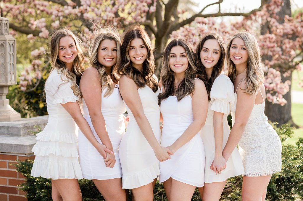Michigan State University senior photo ideas with roommates on campus in white dresses with a magnolia tree in the background, by Allie Siarto & Co, senior photographers in East Lansing, Michigan
