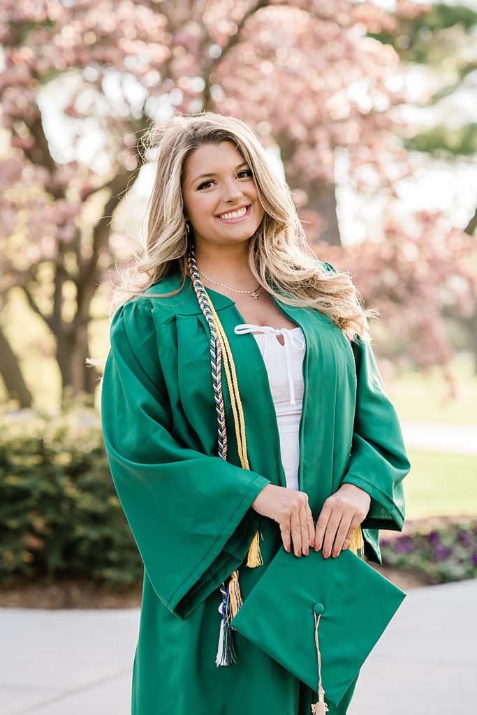 Michigan State University senior photo ideas with roommates on campus in white dresses and cap and gown with a magnolia tree in the background, by Allie Siarto & Co, senior photographers in East Lansing, Michigan