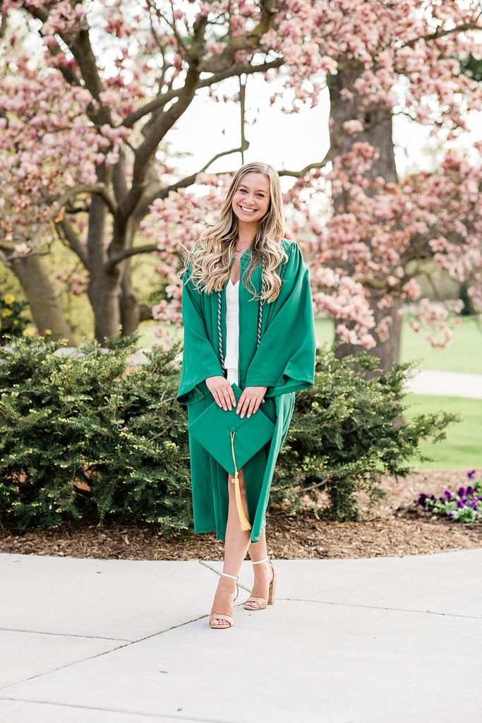 Michigan State University senior photo ideas with roommates on campus in white dresses and cap and gown with a magnolia tree in the background, by Allie Siarto & Co, senior photographers in East Lansing, Michigan