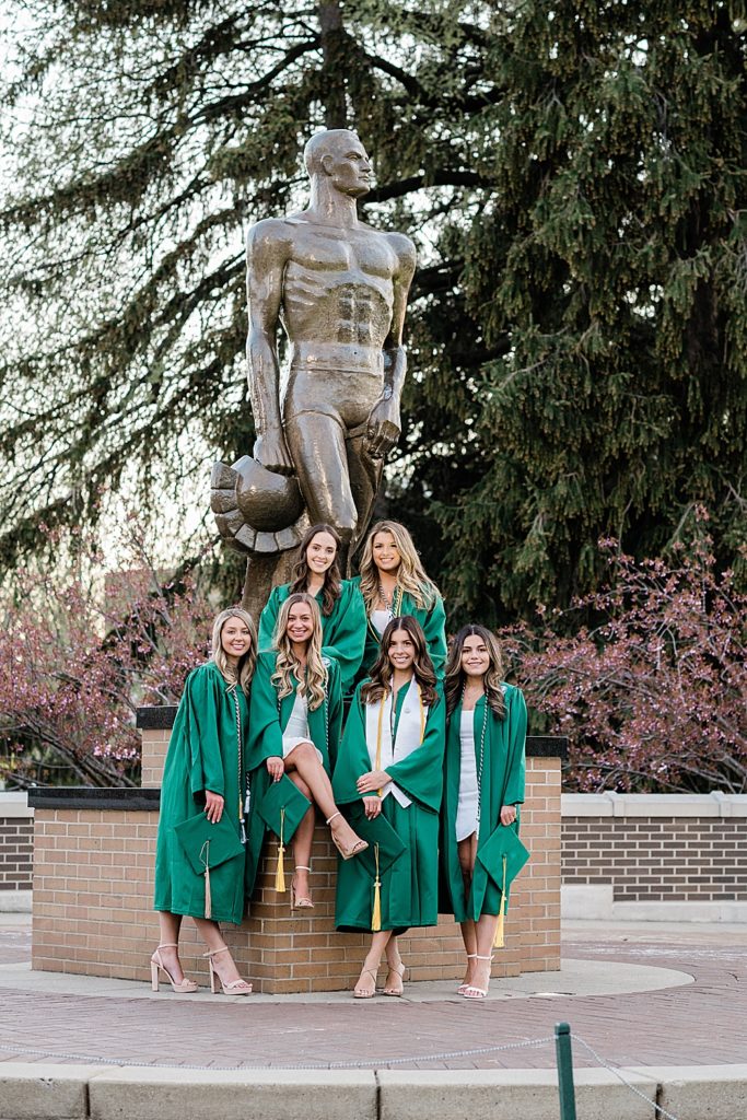 Michigan State University senior photography ideas with roommates on campus in white dresses and cap and gown in front of Sparty, by Allie Siarto & Co, senior photographers in East Lansing, Michigan