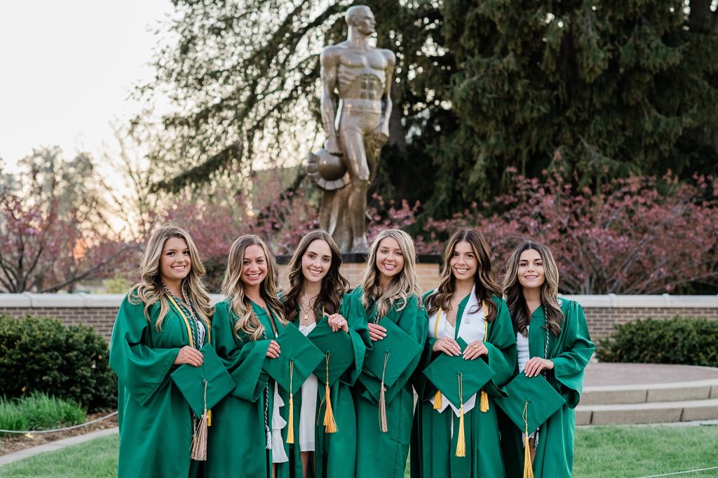 Michigan State University senior photography ideas with roommates on campus in white dresses and cap and gown in front of Sparty, by Allie Siarto & Co, senior photographers in East Lansing, Michigan