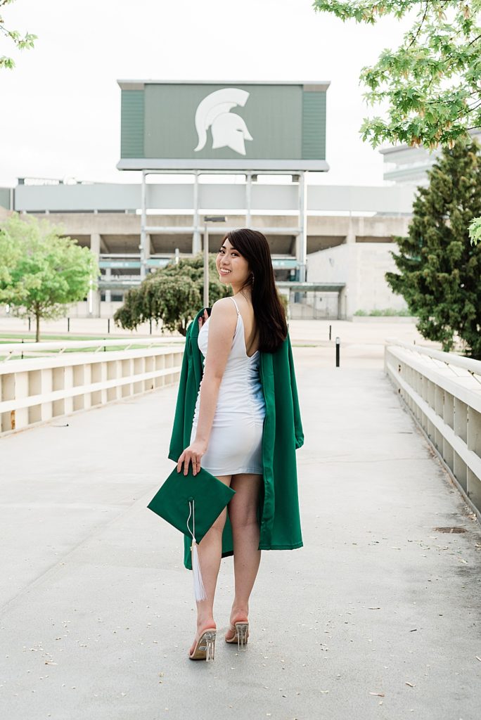 Michigan State Senior Graduation Pictures in cap and gown on campus; grad photos on the bridge over the Red Cedar River with Spartan Stadium in the background by Allie Siarto & Co. Photography