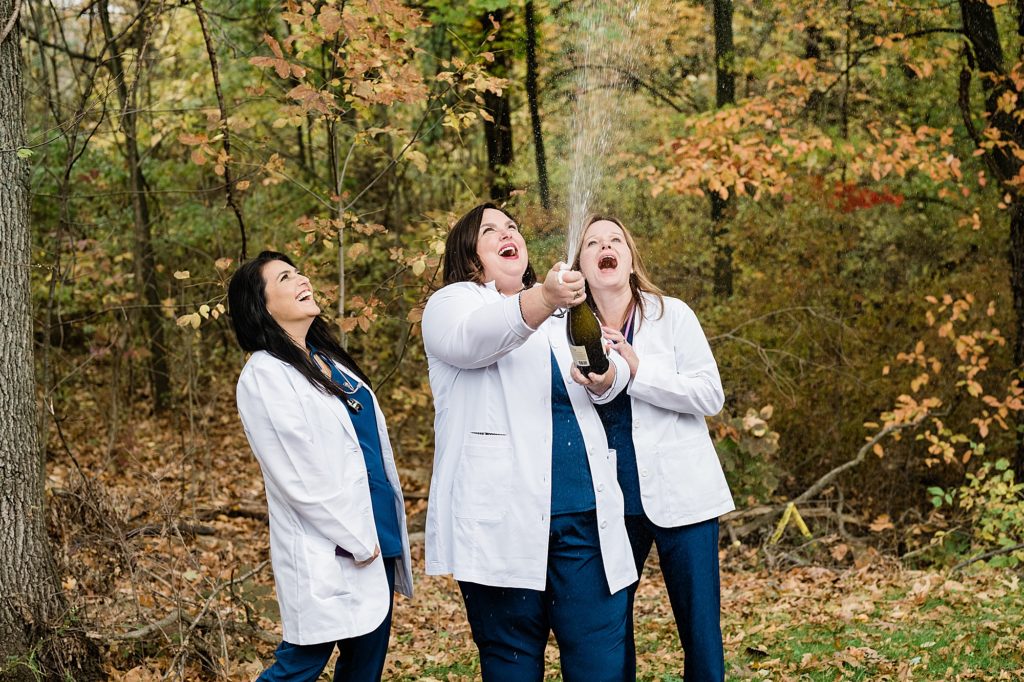 Branding photos with three nurses popping champagne by Allie & Co. Commercial Photography in Lansing, Michigan