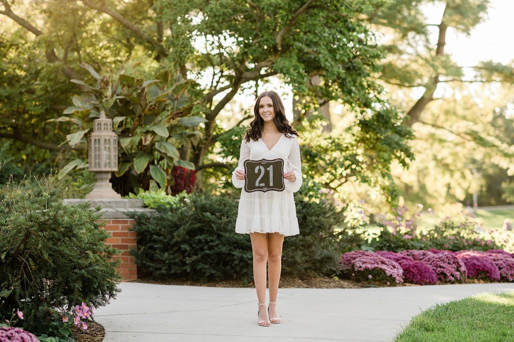 Michigan State graduation pictures on north campus with a white dress and 21st birthday sign by Allie & Co. Photography, East Lansing photographers