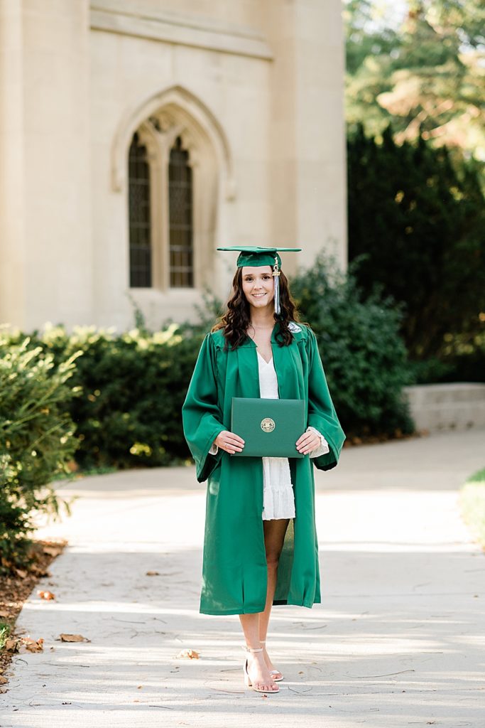 MSU graduation pictures on north campus in the fall with a white dress, cap, grad gown, and diploma with Beaumont Tower in the background by Allie & Co. Photography, East Lansing photographers