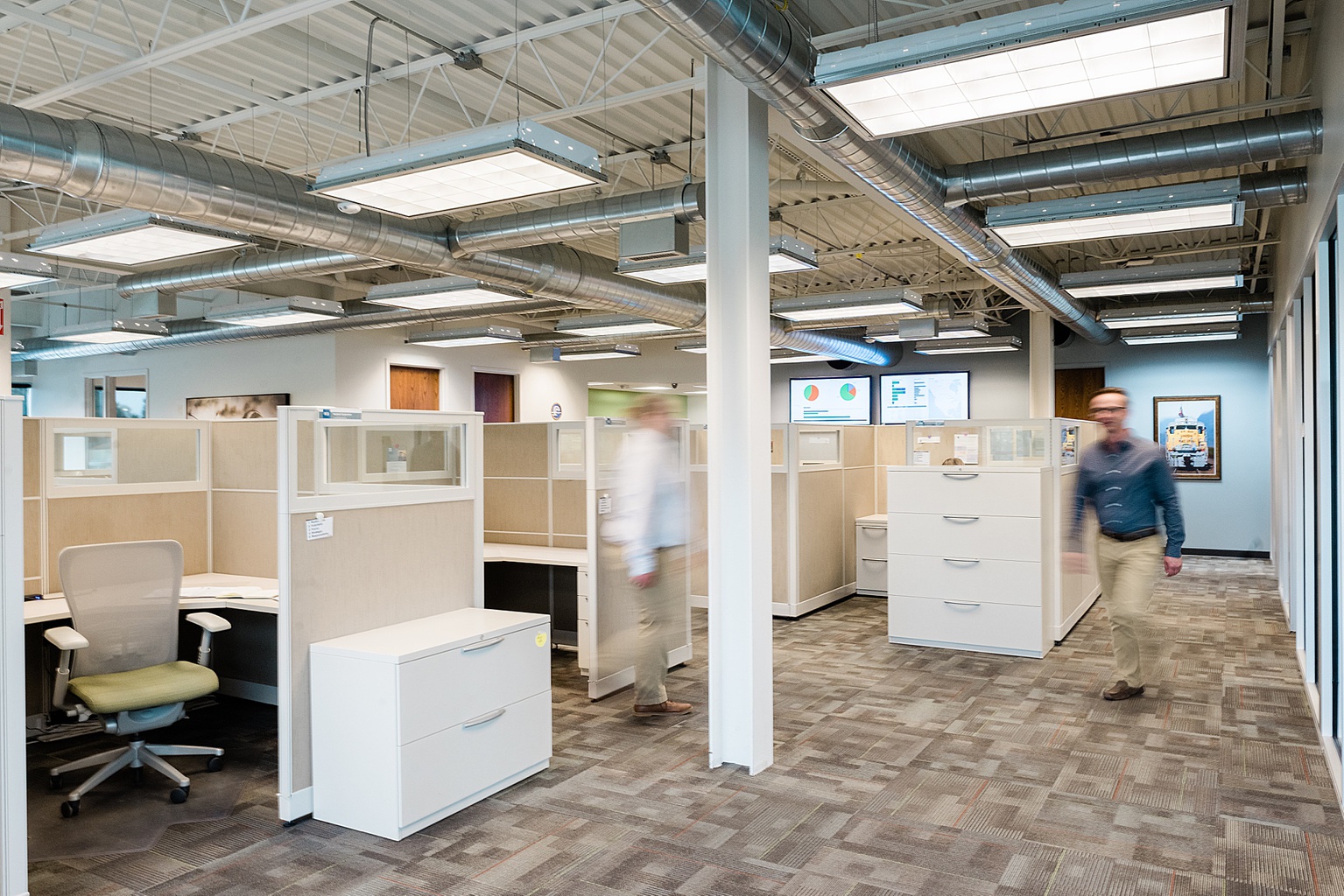 Lansing commercial photography - photo of two men walking through an office with motion blur, cubicles behind them, by Allie Siarto & Co., Lansing branding and commercial photographer 