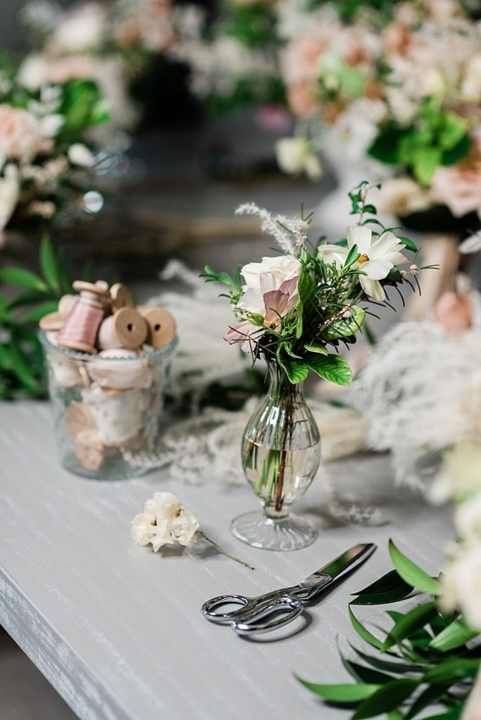Product photo of a vase with flowers and a jar of pink ribbons behind, along with a table and chairs by Allie Siarto Photography, East Lansing, Michigan product photographers