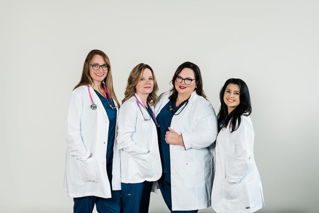 Lansing headshot photographer, photo of a group of nurses in their uniforms with stethoscopes in front of a  white background, by Allie Siarto & Co, Lansing, Michigan branding photographers