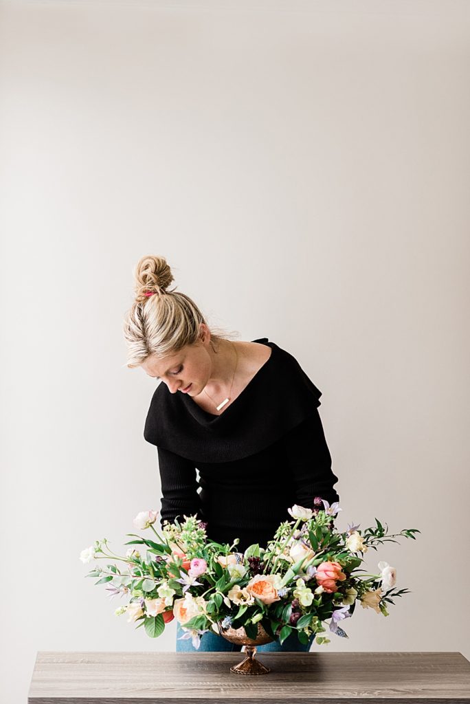 Lansing headshot photographer, photo of a florist arranging flowers against a white backdrop, by Allie Siarto & Co, Lansing, Michigan branding photographers