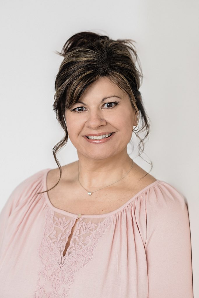 Lansing headshot photographer, photo of a woman wearing a pink shirt against a white backdrop, by Allie Siarto & Co, Lansing, Michigan branding photographers
