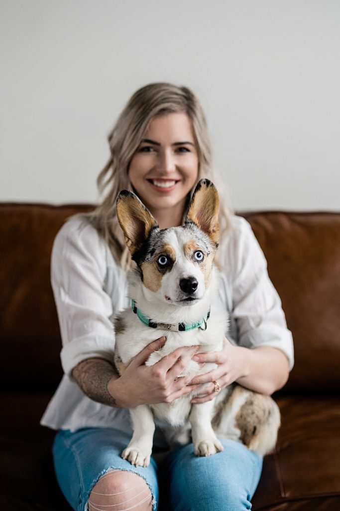 Lansing head shot photographer, photo of a woman sitting on a brown couch with her dog in her lap, by Allie Siarto & Co. Photography, Michigan branding photographers