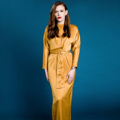 Fashion photo of a model wearing a yellow dress on a bright blue seamless background by Allie Siarto & Co. Photography, Lansing commercial photographer
