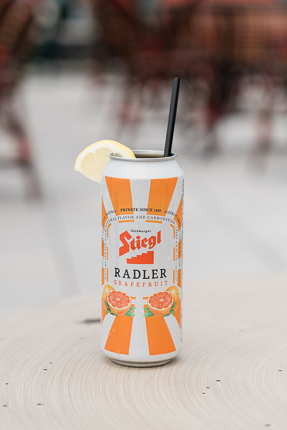 Graduate Rock bar commercial photography showing a glass with a can of Stiegl Radler Grapefruit with a lemon wedge, by Allie Siarto & Co. Photography, Lansing, Michigan commercial photographers