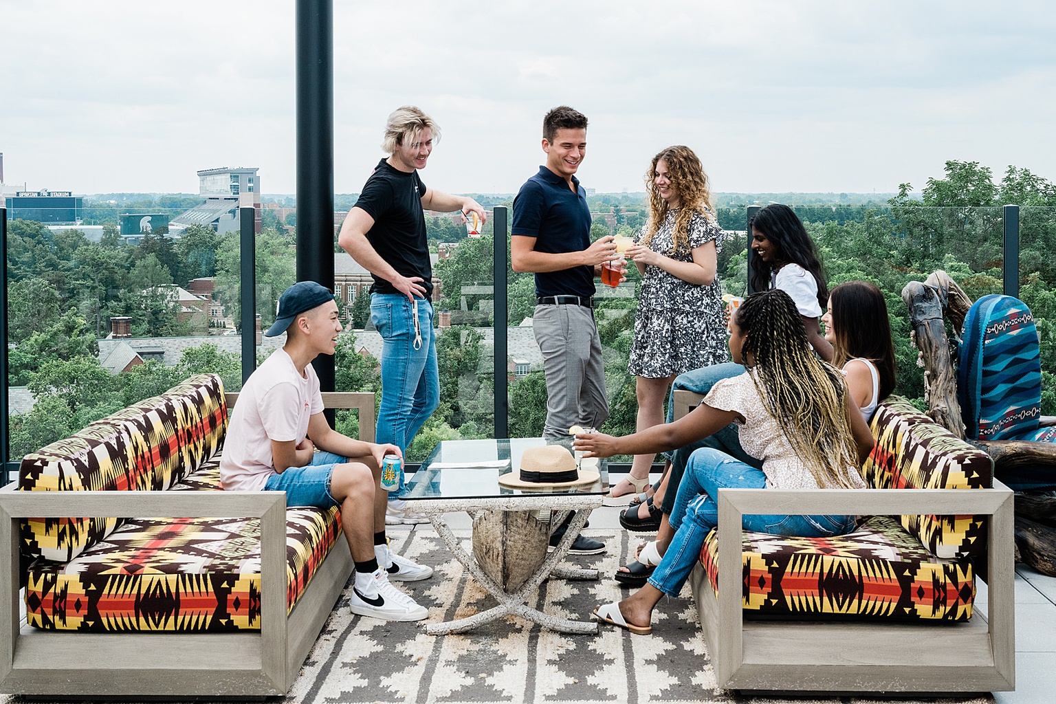Graduate Rock bar commercial photography showing the rooftop bar with college students enjoying drinks together, overlooking Spartan Stadium and the Michigan State campus, by Allie Siarto & Co. Photography, Lansing, Michigan commercial photographers