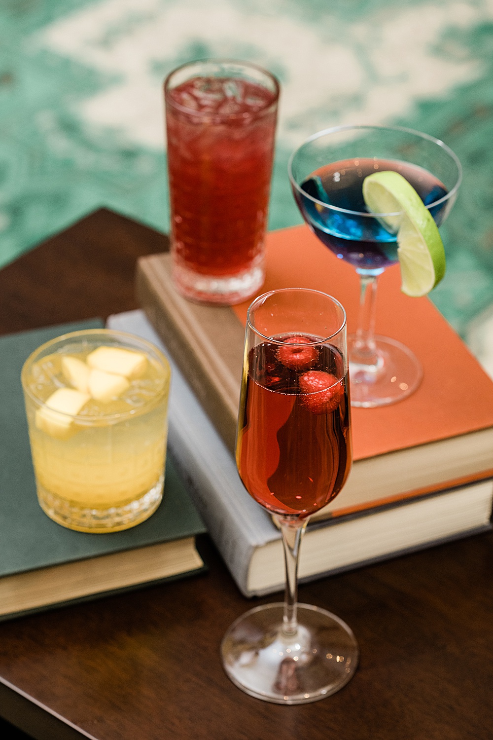 East Lansing's Graduate Hotel School Spirits Dinner, photo of all mixed drinks stacked on books, by Allie Siarto & Co. Photography, Lansing commercial photographer