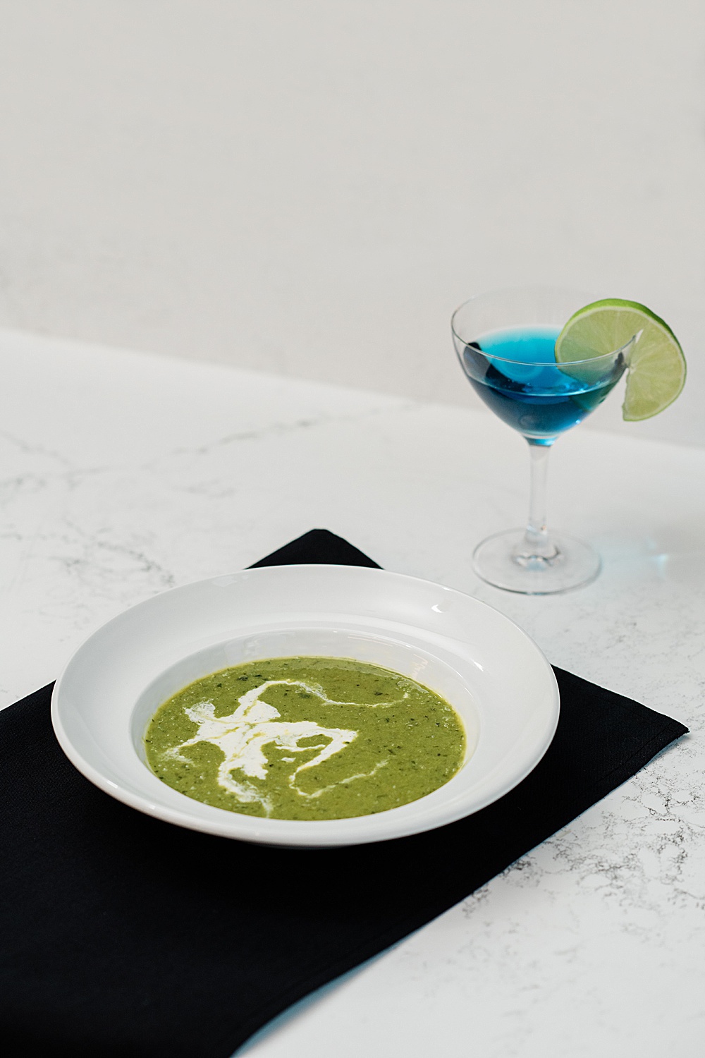 East Lansing's Graduate Hotel School Spirits Dinner, photo a split pea soup and blue martini drink with a lime, by Allie Siarto & Co. Photography, Lansing commercial photographer
