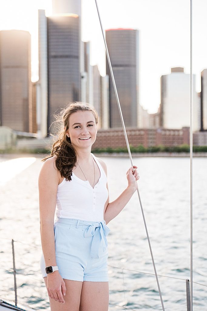 Detroit, Michigan headshot branding photos of a young photographer standing on a sailboat and smiling at the camera, surrounded by the Detroit River - by Allie Siarto & Co. Photography, Michigan commercial and editorial photographers