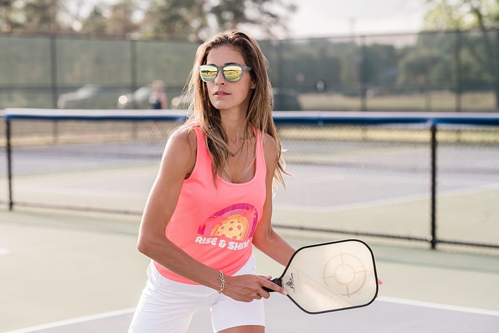 Product photo of a woman wearing a pink shirt from a pickle ball clothing line by Allie Siarto Photography, East Lansing, Michigan product photographers