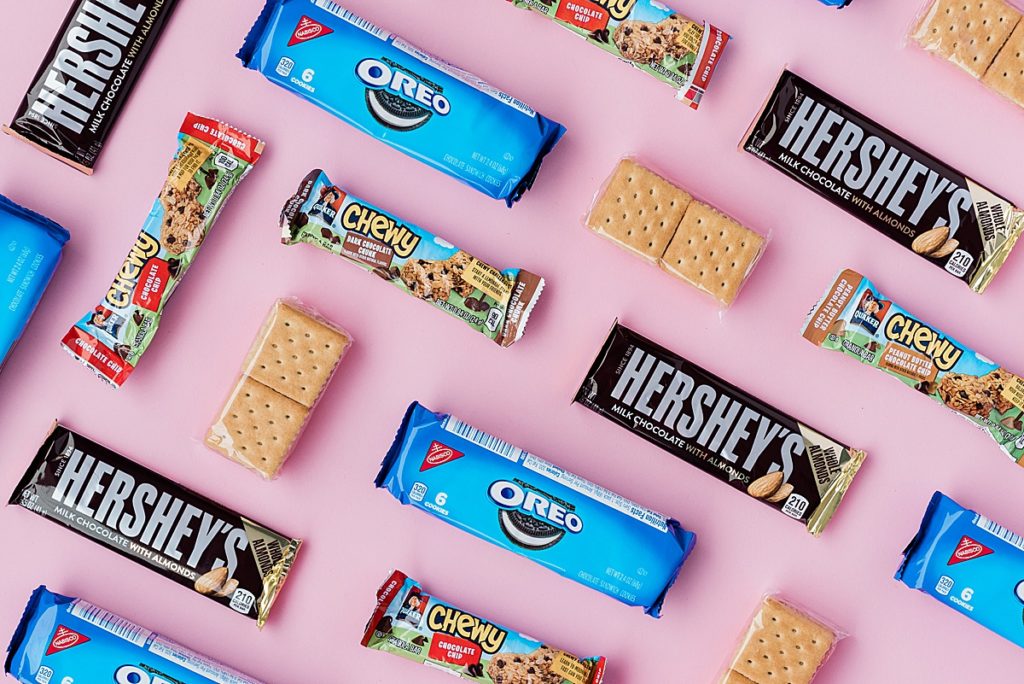 Product photo of a series of Oreos, crackers, and Hershey's bars on a pink backdrop by Allie Siarto Photography, East Lansing, Michigan product photographers