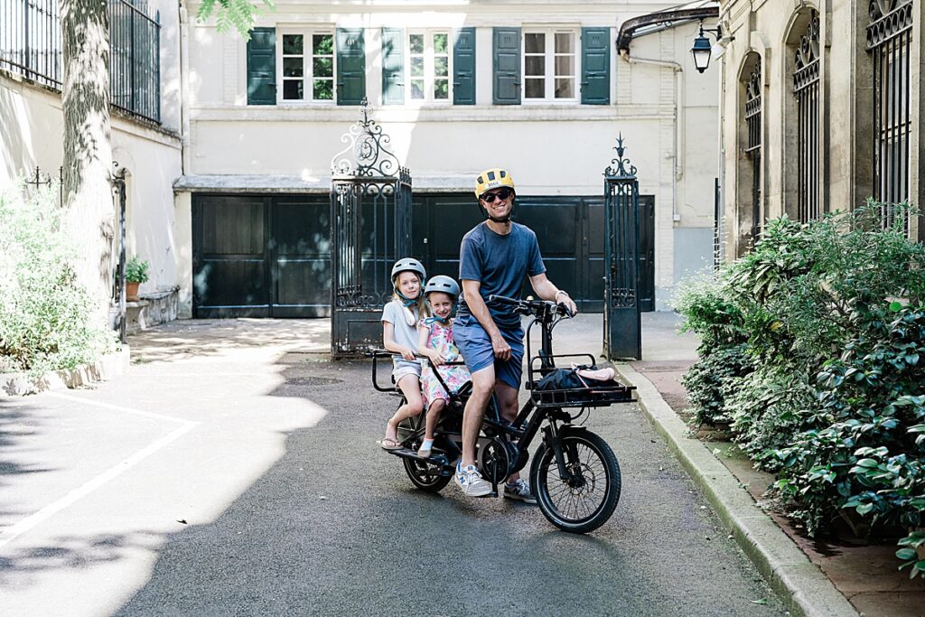 Riding a long tail cargo bike with kids in Paris, France.