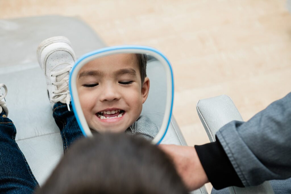 dentist marketing photos by Allie Siarto, Lansing, Michigan headshot and marketing photographer; a photo of a young boy looking in a handheld mirror