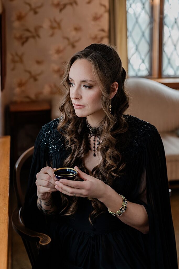 Creative solopreneur headshots: Audio book narrator Bridgerton inspired headshots by Allie Siarto Photography, headshot and portrait photographer out of East Lansing, Michigan - an audiobook narrator reads holds a vintage teacup in a Victorian setting